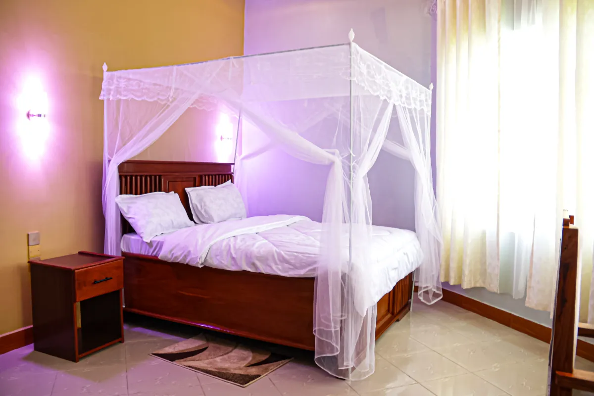 Comfortable bed in a room at JK Maasai Hotel